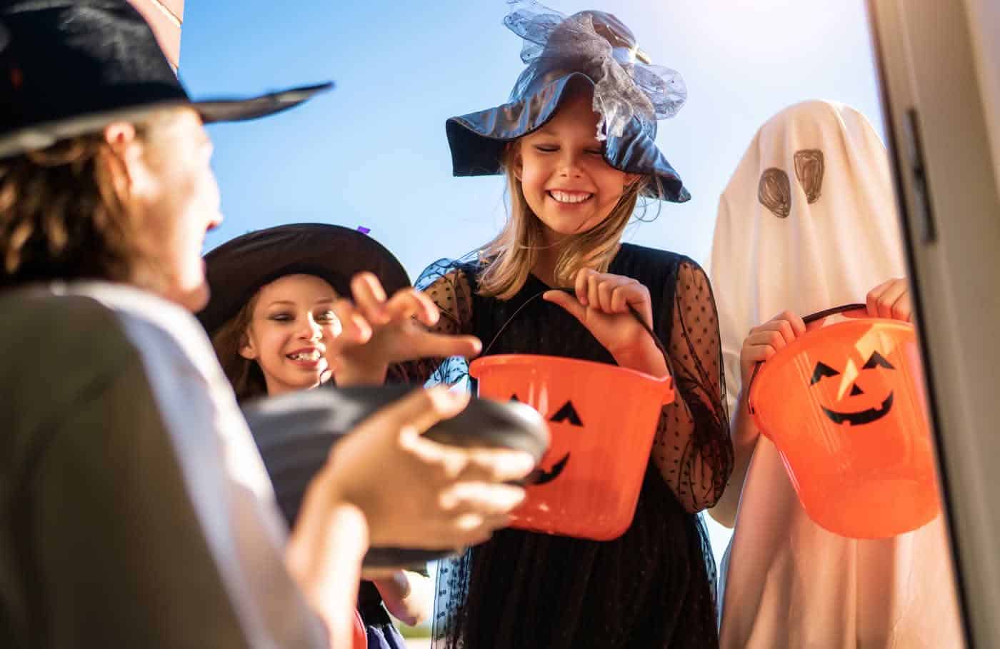 trick or treaters getting candy from a neighbor